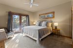 Large bright master bedroom on main floor with french doors opening out to private seating area on deck